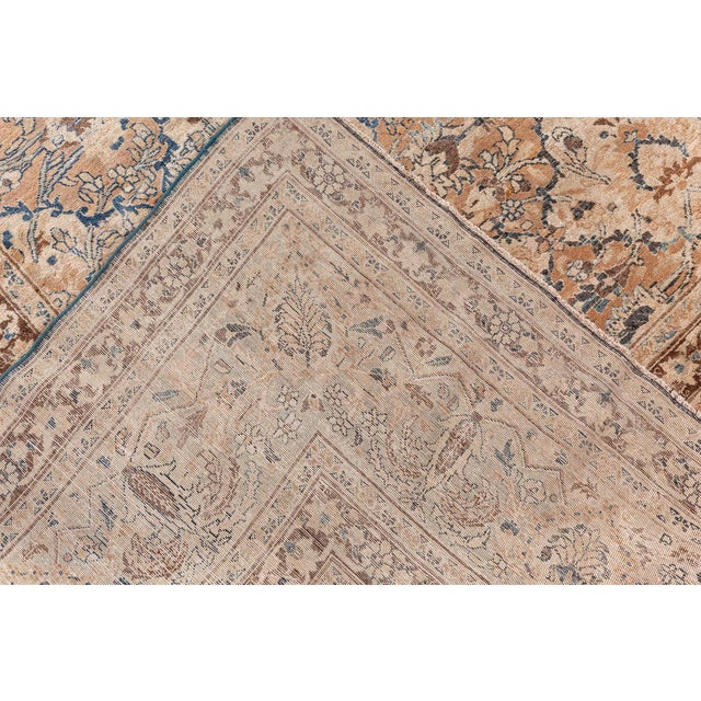 An early 20th century Persian Meshad (Meshed) antique rug having a camel and sand lozenge lattice overall with delicate...