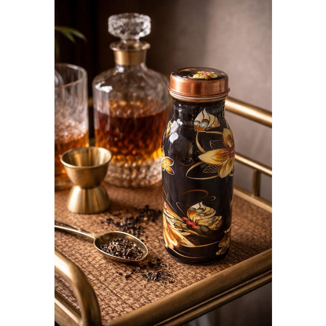 A beautifully detailed mid-century Asian lacquer tea caddy featuring a rich black ground adorned with hand-applied floral...