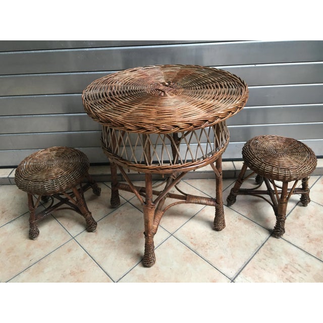 A set of a table and 2 small wicker stools. The set is in good condition. Coffee table: height 62 cm x 54.5 cm Table in...