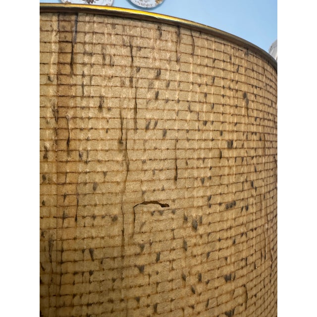 Listing is for a midcentury lampshade. I believe the drum shaped lampshade is made of some kind of paper or natural fiber.