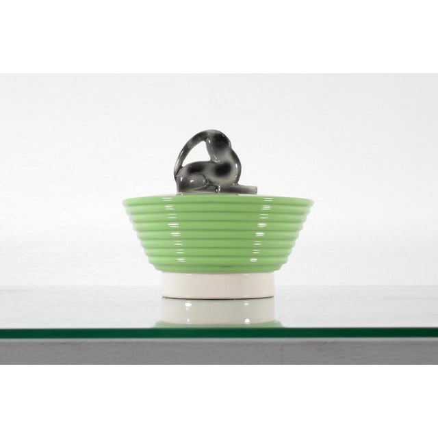 Very stylish ceramic soup tureen with a light green and white glaze. The lid handle features a stylized, airbrushed animal...