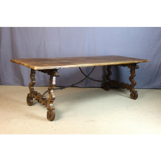 Spanish walnut dining table with a base connected by an 18th-century wrought iron stretcher; the tabletop is more recent,...