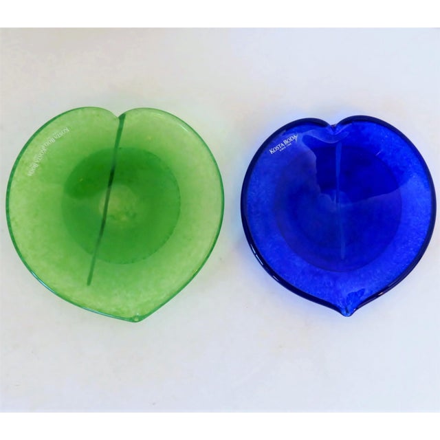 Two heart-shaped blown glass small shallow bowls by Swedish artist Gunnel Sahlin. One dish is in bright blue and one is in...