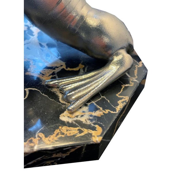 Art Deco table lamp by “Carvin” Silver-plated Art Deco lamp with 2 seals playing with a ball. Signed on the marble top....