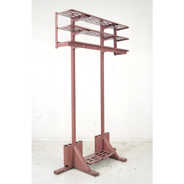 Mid 20th century coat rack made of steel with a dark pink painted finish. Made by Gingher MFG. Co. in Scranton, PA. It is...