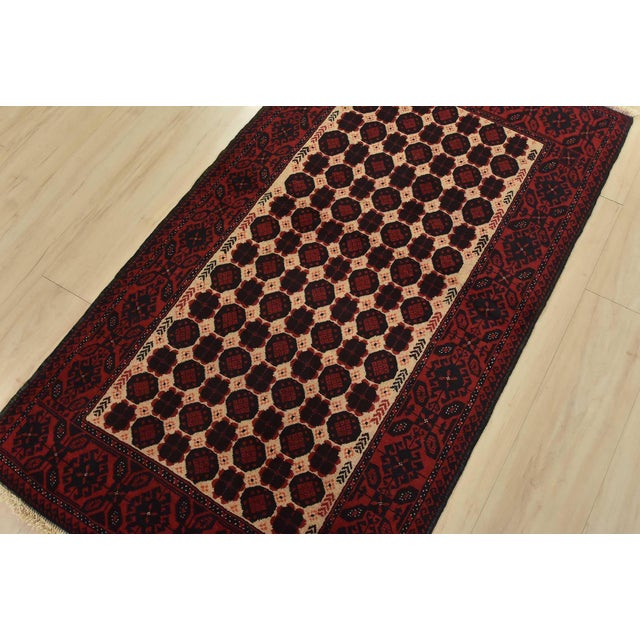 An authentic vintage tribal Baloch rug hand-knotted with fine wool and natural dyes. This nomadic oriental rug features an...