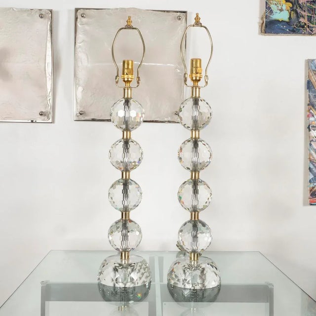 Pair of table lamps composed of stacked faceted glass spheres with faceted glass bases and brass hardware.
