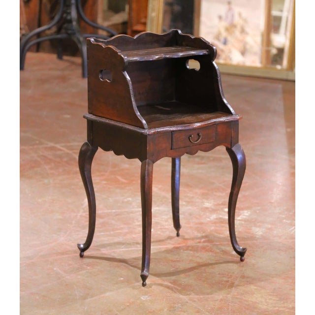This charming 18th-century French nightstand was crafted in solid oak and showcases the curving elegance of the Louis XV...