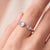A bold, contemporary open-cuff ring featuring two luminous moonstones — an oval-cut stone paired with a round-cut stone —...