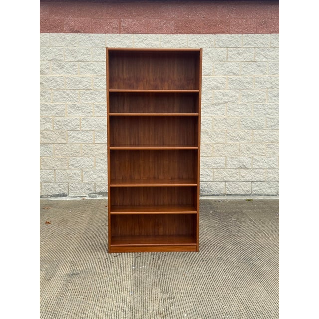 Vintage Mid-Century Modern bookcase featuring warm teak construction with beautifully figured wood grain throughout....