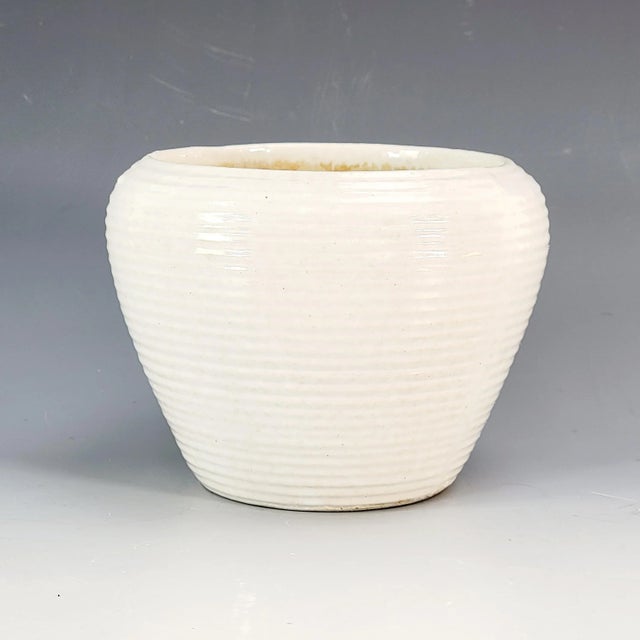 Wheel-thrown and studio-crafted, this mid-century vase features a softly tapered profile with a horizontal banded texture...