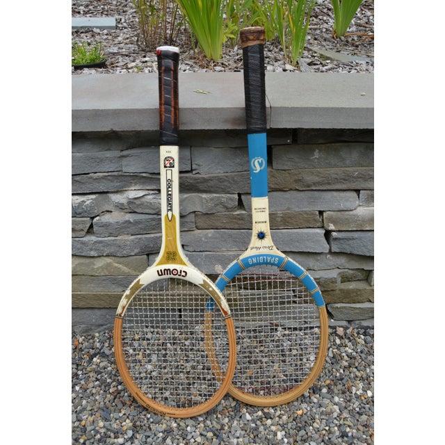 A classic pair of vintage wooden tennis racquets featuring a Crown Collegiate model and a Spalding Doris Hart signature...