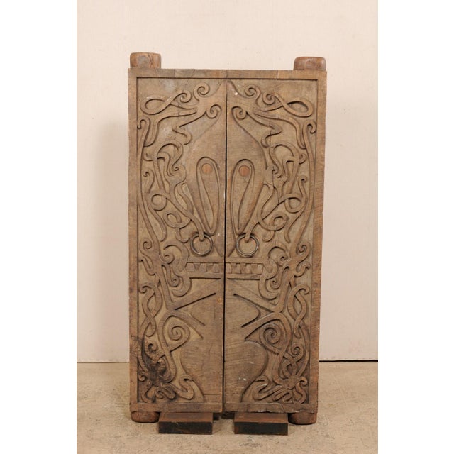 A pair of hand-carved wooden doors from Borneo on custom iron bases, mid 20th century. This vintage pair of doors from the...