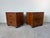A handsome pair of vintage Baker Furniture campaign style nightstands featuring rich wood, recessed brass hardware, and...