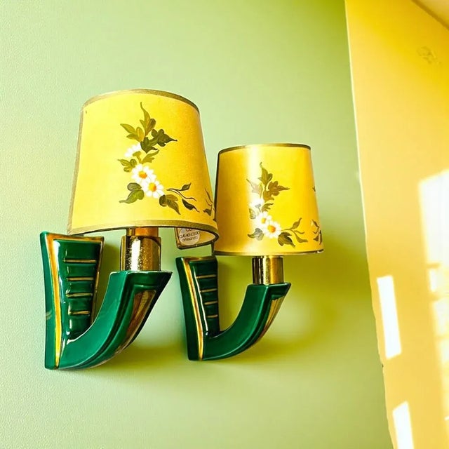 Pair of French green and gold ceramic wall sconces equipped with clip-on hand-painted half-shades. The shades are...