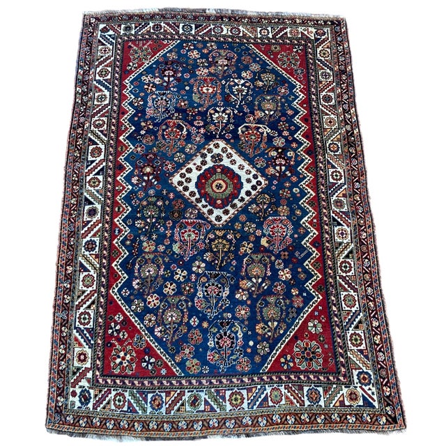 A stunning antique tribal rug, hand woven by the nomadic Qashqai tribe circa 1910. The design features a small geometrical...