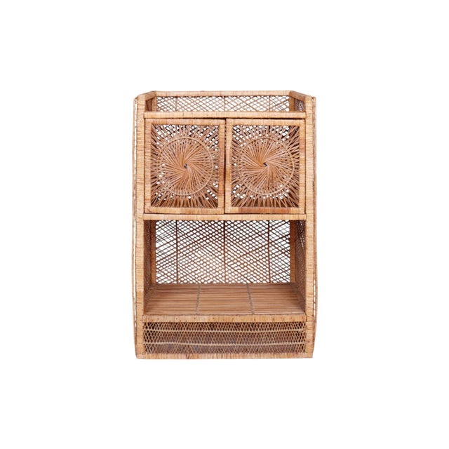 A coastal style rattan bar cabinet with sunburst design in front. A squared wooden frame is wrapped with woven rattan...