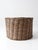 A large antique woven basket in a warm, natural tone with a grounded, organic presence. Its rounded form and subtle...