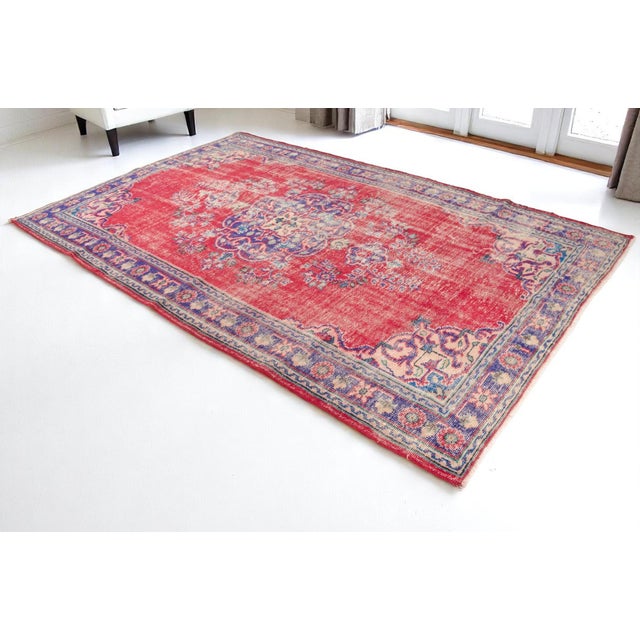 This is a vintage Turkish Oushak rug from the Mid 20th Century. The piece was hand-knotted.