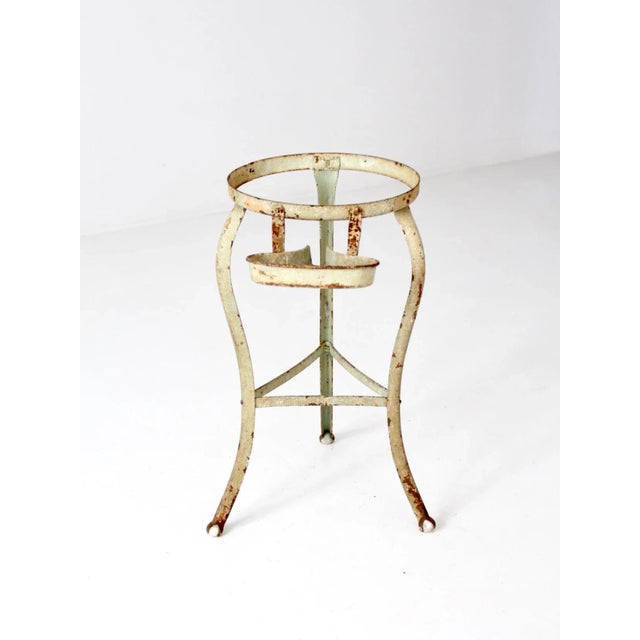 Antique iron pedestal stand dating to the late 19th century, finished in a soft green with a naturally aged patina. The...