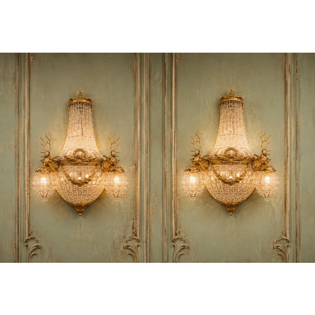 This decorative pair of French wall sconces dates to approximately 1980 and combines classical Louis XVI styling with a...
