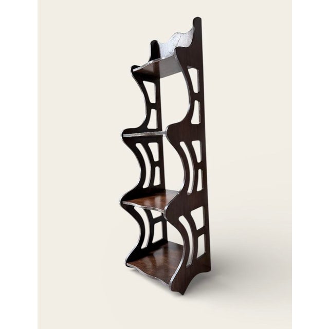 This is a vintage dark brown wooden display shelf with four shelves and intricate cutouts. It’s can be stand or hanging on...