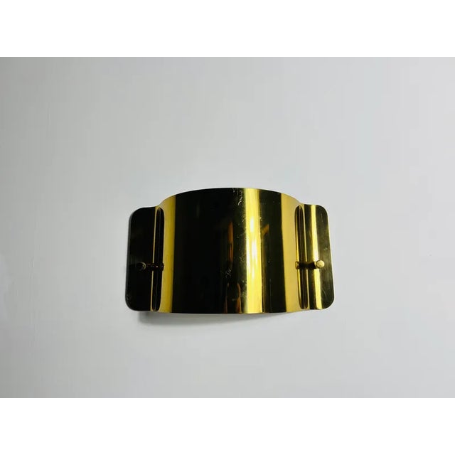 This exquisite wall lamp, crafted in italy during the 1960s, is made entirely of solid brass, showcasing a sleek, angular...