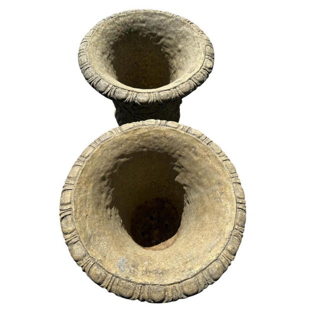 This impressive pair of cast stone garden urns is executed in the grand Italian Renaissance manner, each raised on a...