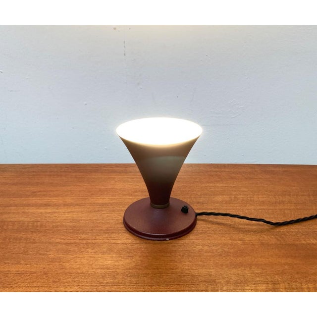 Mid Century table lamp from Italy. The lamp shows a classic funnel shape. The shape of the umbrella rejuvenates close to...