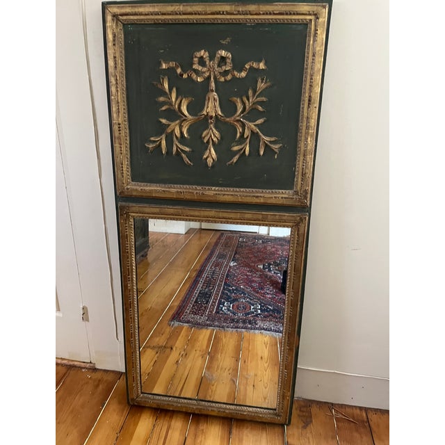Lovely green and gold French “tremeau” mirror in the Neoclassical style, mid‐ to late 19th century. Carved wood with a...