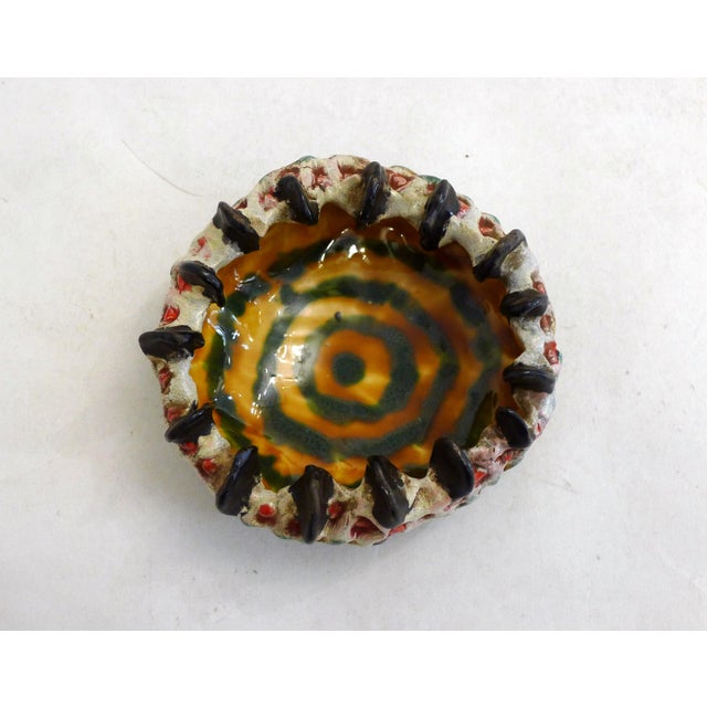 Organic-style ashtray and trinket dish, round in shape with a relief-carved design resembling coral or plant life on the...