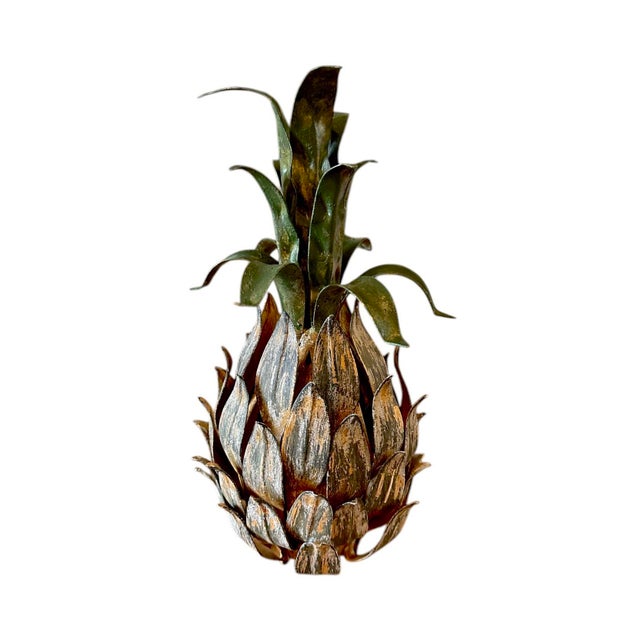 A charming, vintage tole pineapple object. Features a cast metal pineapple in shades of ochre, green and gold topped with...