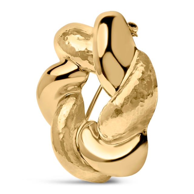 Crafted with the utmost artistry, this brooch embodies a perfect sculpted knot, meticulously wrought from refined 18K...