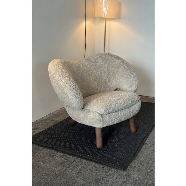 The Pelican Lounge Chair in Sheepskin and Walnut by Finn Juhl is a iconic lounge chair hand crafted in Denmark. This mid-...