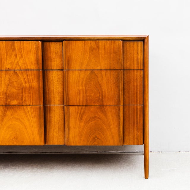 A newly refinished nine-drawer walnut lowboy chest of drawers designed by Barney Flagg for Drexel’s “Parallel” collection,...