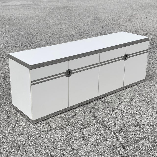 A sleek and sophisticated 1970s design by Pierre Cardin, this long, low white cabinet has linear graphic elements and...