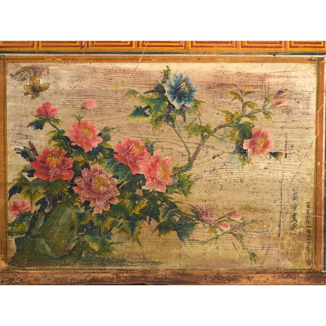 This antique Chinese trunk with painted panel in elm is a dowry chest with a sliding lid and a painted panel framed in...