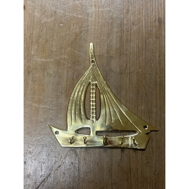 This vintage brass key hook rack, crafted in the shape of a sailboat, is a beautifully balanced blend of form and...