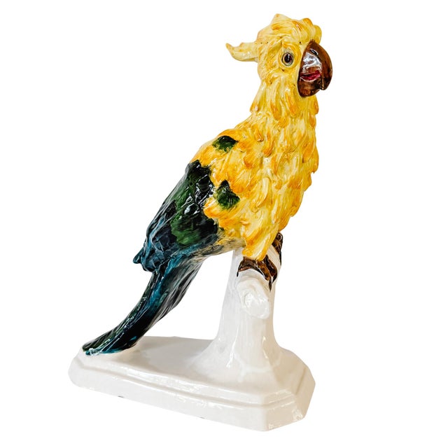 A vibrant Mid-Century Italian majolica ceramic cockatoo figure, hand-painted in rich shades of sunny yellow, emerald...