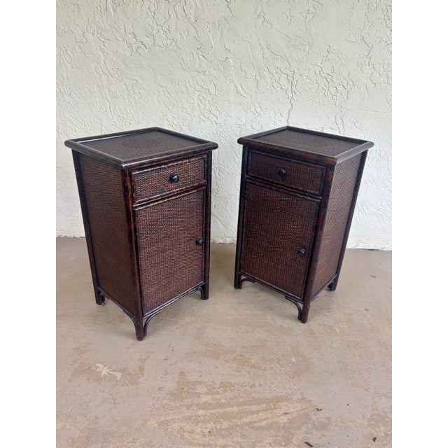 Vintage late 20th-century pair of British Colonial style nightstands or end tables featuring faux burnt bamboo frames with...