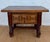 Charming Spanish side table crafted from wood, featuring a rectangular top and a beautifully carved front with geometric...