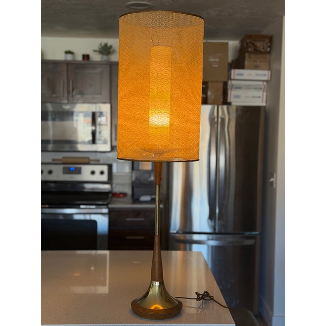 Vintage Modeline table lamp, circa 1960s. Sculptural wood and brass base with original two-part shade. The shade features...