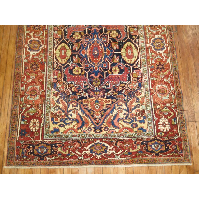 An authentic full pile Persian Heriz rug. The palette is formal, the border is an orangy red cast to it while the field is...