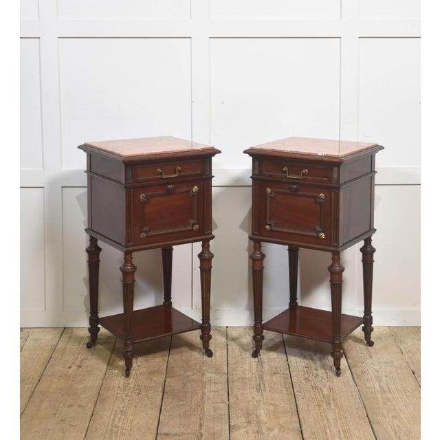 This sophisticated pair of early 20th-century mahogany bedside cabinets offers both decorative refinement and practical...
