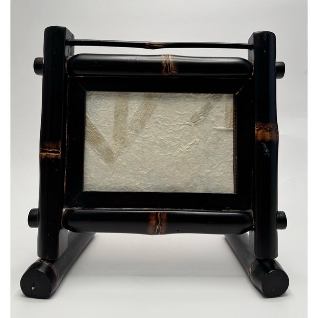 A self supported stand holds this Asian inspired faux bamboo tabletop picture frame. The frame consists of wood embossed...