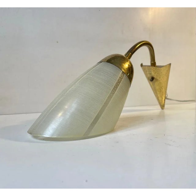 Early 1950s wall light made in Scandinavia in a style reminiscent of Stilnovo and the french modernist movement. Its...