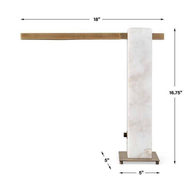 A slender metal arm with antique brass finish rests on white marble to form this lamp scaled for desks or bedsides. The...