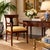 Elegant vintage Hollywood Regency Neoclassical-style armchair featuring a warm mahogany-toned wood frame with graceful...