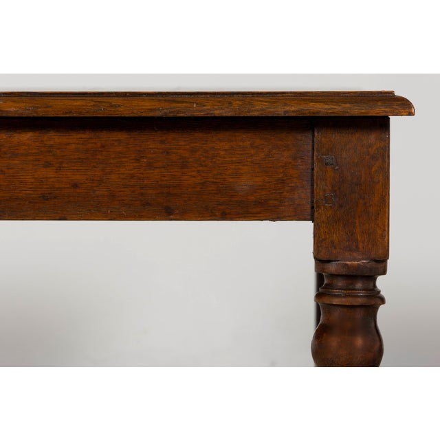 Late 19th century French Louis XVI style writing table crafted in oak, sourced in Provence, France. The table features a...