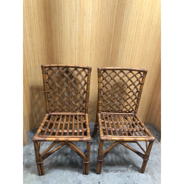 Vintage pair of weaved back rattan dining chairs with woven leather wrapped around frames. 33” H. X 18” D. X 18.5” W. Seat...